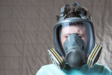 portrait of a boy in a light t-shirt with a gas mask