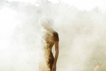 young woman in black outfit hidden by smoke