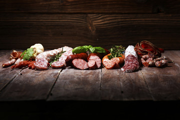 cold meat assortment with delicious salami and  fresh herbs . Variety of meat products including...