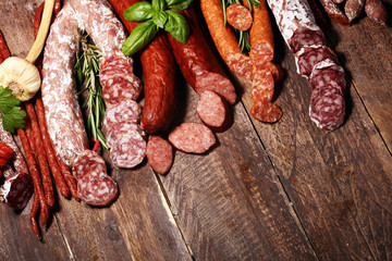 cold meat assortment with delicious salami and  fresh herbs . Variety of meat products including...