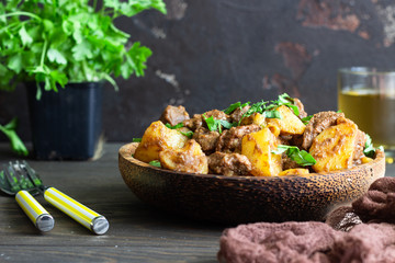 Meat stew with potatoes and parsley in wooden dish. Traditional Portuguese meat stew. Wooden background.