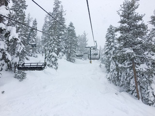 Empty chairlift with White fluffy Snow Piled Below
