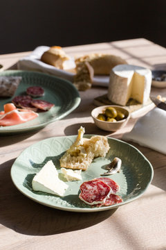A european inspired lunch of baguette, cheese, charcuterie, olives and anchovies.