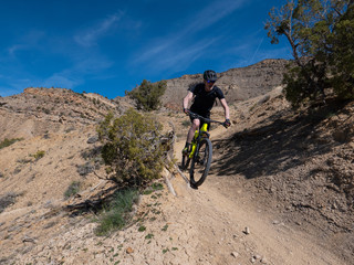Obraz premium Active senior riding a mountain bike on singletrack in Colorado