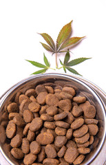 Dog treats and cannabis leaves isolated over white background - CBD and medical marijuana for pets concept