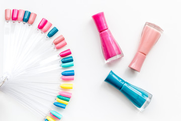 work desk at nail bar with nail polish and palette for manicure on white background top view