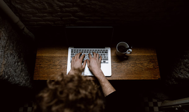man typing on a laptop