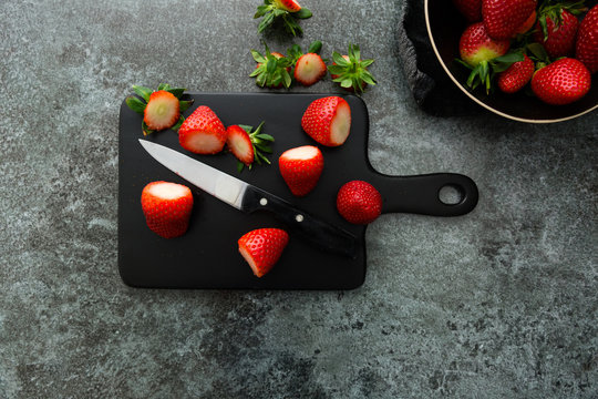 Overhead of topped fresh strawberries on chopping board