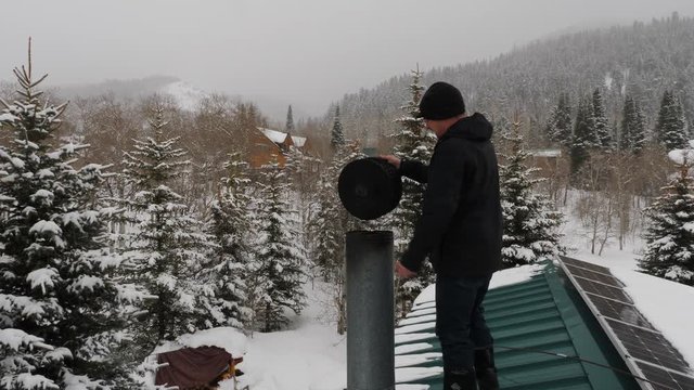 Chimney sweep on the roof in winter