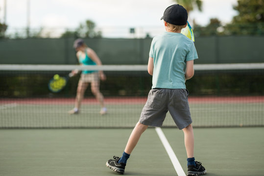Mother and son enjoy physical fitness together playing tennis