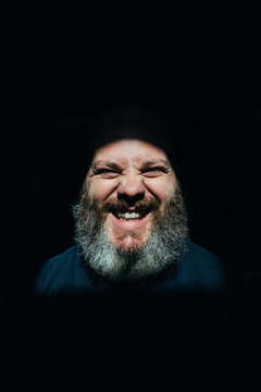 Bearded man over black background with eyes closed