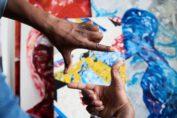 Back view of painter measuring his artwork with hands.