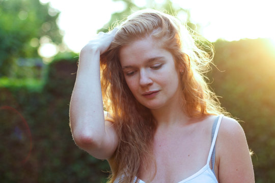 Relaxed redheaded young woman enjoying sunlight