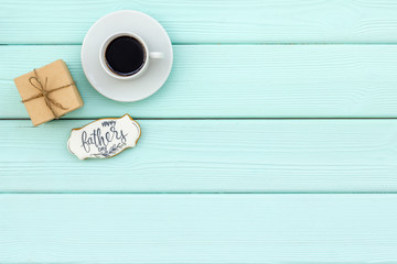 cup of coffee, gift and copy for Happy Father Day party on mint green wooden background top view copy space