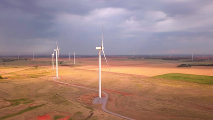 Dramatic aerial shot of wind farm with storm in background in Oklahoma.
