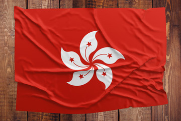 Flag of Hong Kong on a wooden table background. Wrinkled flag top view.