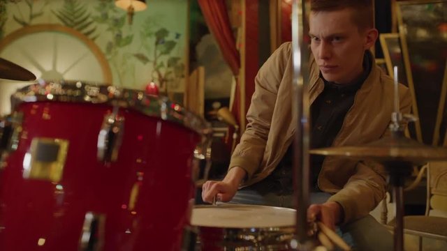 Drummer tightening drumhead in nightclub / Provo, Utah, United States