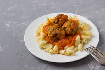 Meatballs with pasta on a plate.