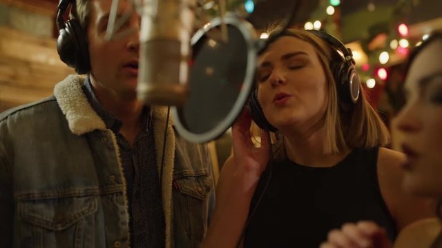 Slow motion close up of singers wearing headphones recording vocals with microphone / Provo, Utah, United States