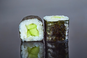 Classical vegan roll sushi with cucumber on black background for menu. Japanese food