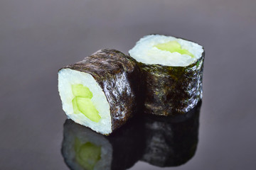 Classical vegan roll sushi with cucumber on black background for menu. Japanese food