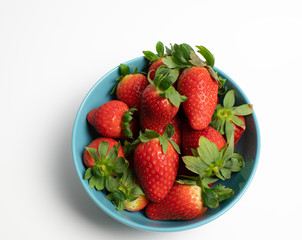 strawberries in blue bowl with white background