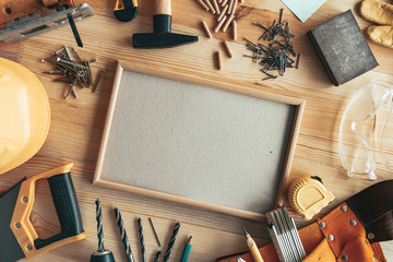 Empty picture frame as copy space on carpentry woodwork desk