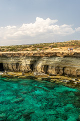 CYPRUS, AYA NAPA - MAY 11, 2008: Tourists stroll along the coast near the picturesque sea caves.