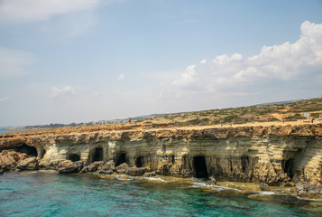 CYPRUS, AYA NAPA - MAY 11, 2008: Tourists stroll along the coast near the picturesque sea caves.