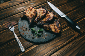 Pork bone steak on a wooden background with honey. Board slate. kenza, pepper