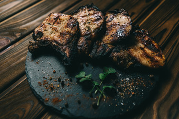 Pork bone steak on a wooden background with honey. Board slate. kenza, pepper
