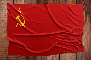 Flag of Soviet Union on a wooden table background. Wrinkled USSR flag top view.