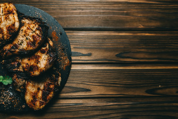 Pork bone steak on a wooden background with honey. Board slate. kenza, pepper