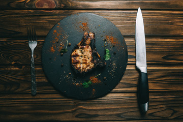 Pork bone steak on a wooden background with honey. Board slate. kenza, pepper