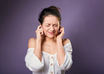 Stressed unhappy casual woman closed ears the fingers because not want the hear any sounds and noise