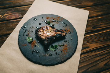 Pork bone steak on a wooden background with honey. Board slate. kenza, pepper