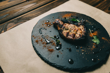 Pork bone steak on a wooden background with honey. Board slate. kenza, pepper