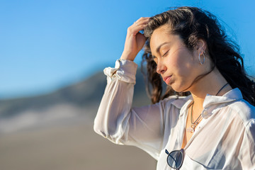 A beautiful young latin girl portrait with straight hair taken by her hand in the outdoors. Wearing casual clothes during a beach day in the Pacific Ocean coastline close to Santiago de Chile