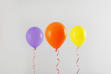 Different bright balloons on light background. Celebration time
