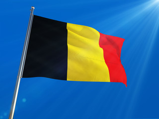 Belgium National Flag Waving on pole against deep blue sky background. High Definition