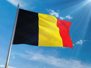 Belgium National Flag Waving on pole against sunny blue sky background. High Definition