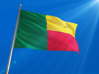 Benin National Flag Waving on pole against deep blue sky background. High Definition