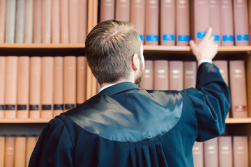 Anwalt mit Robe ist fertig für das Gericht, nimmt aber ein paar Bücher mit