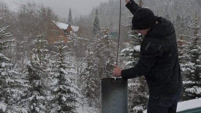 Man cleaning out chimney pipe in a snow storm