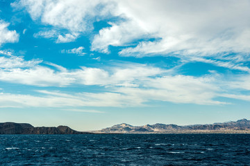 Fototapeta na wymiar Seascape, view of the blue sea with high bald mountains in the background