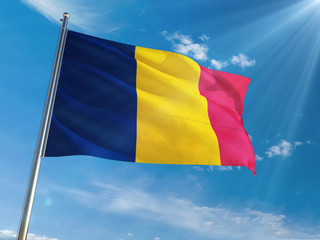 Chad National Flag Waving on pole against sunny blue sky background. High Definition
