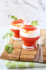 Two verrines of appetizer. Grilled red bell pepper mousse, cream cheese and red caviar