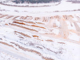Log storage forest, winter logging, sawmill. Top view, aerial.