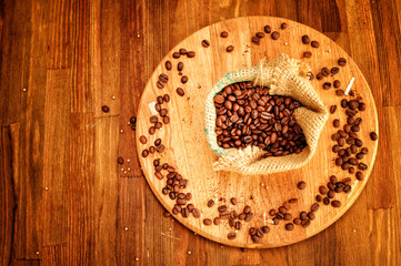 Coffee beans in burlap sack on old style background