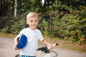 Fototapeta na wymiar Little boy in helmet learning to ride bicycle park having fun.